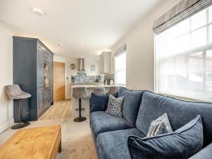Wainfleet All SaintsにあるThe Cooperage- Uk34818の青いソファとキッチンのあるリビングルーム