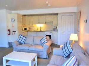 a living room with two couches and a kitchen at Tarquins in Fowey
