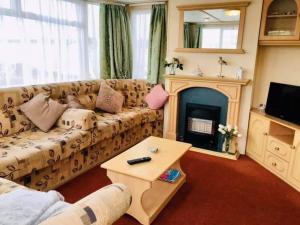 a living room with a couch and a fireplace at Seaside holidays the grange in Ingoldmells