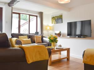 a living room with a couch and a tv at Brameley in Cheriton Bishop +24 photos