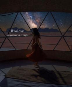 a girl is looking at the night sky at Wadi Rum Relaxation Camp in Wadi Rum