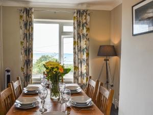 a dining room table with a vase of flowers on it at Bryn Derwen in Llanfair +12 photos