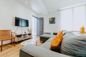 a living room with a couch and a tv at Appartement face aux thermes de vals WIFI-Parking gratuit in Vals-les-Bains +6 photos