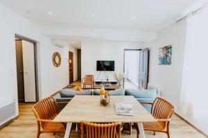 a living room with a table and a couch at Appartement face aux thermes de vals WIFI-Parking gratuit in Vals-les-Bains