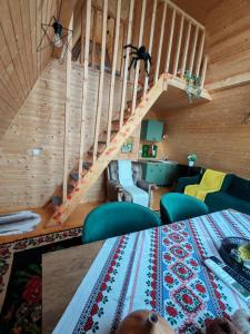a living room with a table and a staircase at Carpatina Runcu căsuțe tip A in Runcu