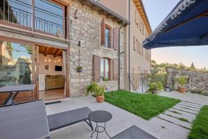 トッリ・デル・ベーナコにあるCasa Silvia II mit Seeblick mit Terrasseの建物の前にテーブルとベンチ付きのパティオ