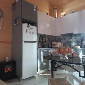 eine Küche mit einem Kühlschrank und einem Tisch mit Obst in der Unterkunft Villa Luna in Boa Viagem