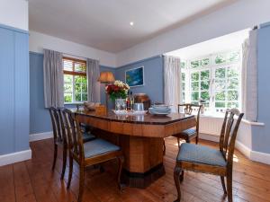 a dining room with a wooden table and chairs at Manorbier Boat House in Manorbier
