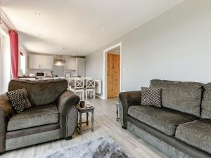 a living room with two couches and a kitchen at Hill Crest Lodge 1 in Hemswell