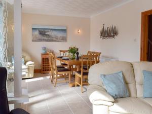 sala de estar con mesa y sofá blanco en Yorke Villa, en Fishguard