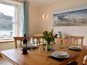 una mesa de comedor con una botella de vino y flores en Yorke Villa, en Fishguard