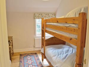 two bunk beds in a room with a window at The Old Stables in Cley next the Sea +13 photos