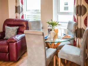a living room with a glass table and a leather couch at Bosun's Cabin - Uk6719 in Lydstep