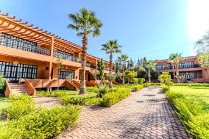 a resort with palm trees and a brick pathway at MVIEW Villas in Marrakech