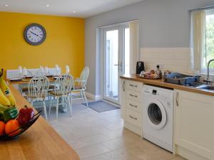 a kitchen with a washing machine and a table at Rotherwood in Portinscale