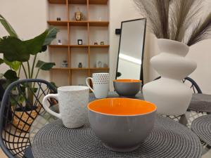 a table with cups and vases on top of it at Kerkétio guesthouse in Tríkala