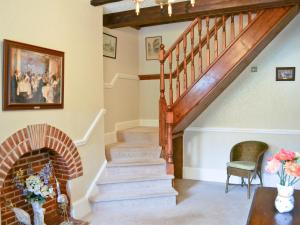 a living room with stairs and a fireplace at Ivy Cottage in Westgate-on-Sea