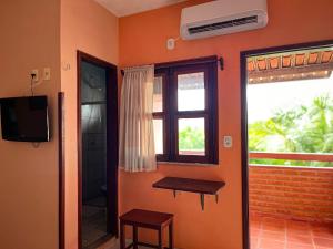 a room with an orange wall with a window at Bela Vista in Canoa Quebrada +41 photos