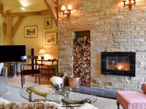 a living room with a stone fireplace with a fire place at Mill Of Burncrook in Glenlivet