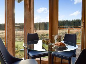 a glass table and chairs in a room with a window at Mill Of Burncrook in Glenlivet