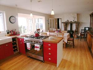 eine Küche mit einem Herd und einem Esszimmer in der Unterkunft Owl Cottage in Kilmote