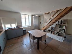 a living room with a table and a staircase at Chez Riri in Saints-Geosmes