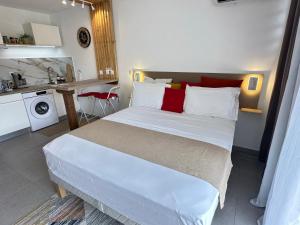 a bedroom with a large white bed with red pillows at Appart de standing - Séjours professionnels et privés in Cayenne