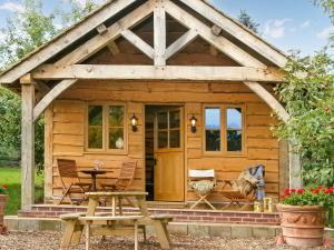 a small wooden cabin with a table and chairs at Copperbeech Bowtop in Tilston