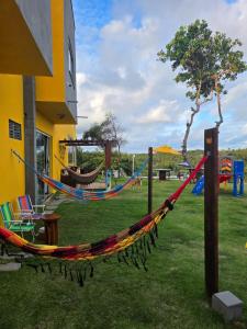 a hammock in a yard next to a playground at Estalagem Solar das Dunas in Pirambu