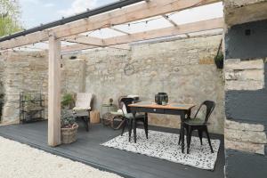 a patio with a table and chairs under a pergola at La Ptite Maison Ardennaise in Rilly-sur-Aisne