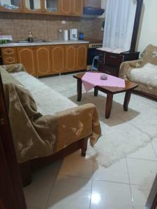 a living room with a table and a couch at Valbona in Korçë