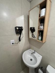 a bathroom with a sink and a mirror at Loft funcional no centro! in Foz do Iguaçu