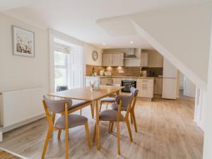 eine Küche und ein Esszimmer mit Tisch und Stühlen in der Unterkunft Dalnaglar Cottage - Uk30260 in Cray