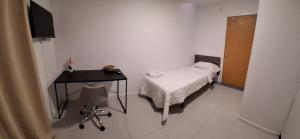 une chambre avec un lit, une table et une chaise dans l'établissement Pensión Alicante Playa, à Alicante