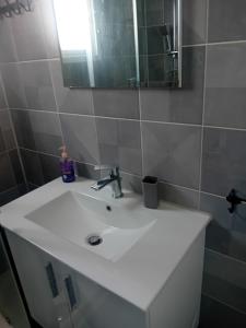 une salle de bains avec un lavabo blanc et un miroir dans l'établissement Smart 2 Bedroom Flat, à Larnaka 5 autres photos