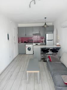 une cuisine et un salon avec un canapé et une table dans l'établissement Smart 2 Bedroom Flat, à Larnaka