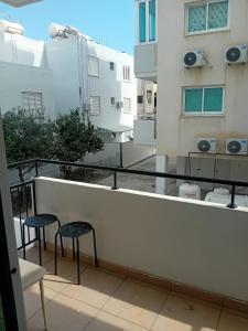 - un balcon avec deux chaises et une vue sur un bâtiment dans l'établissement Smart 2 Bedroom Flat, à Larnaka