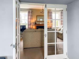 a living room with a couch and a sliding glass door at Six The Square - Uk48869 in Belford +2 photos