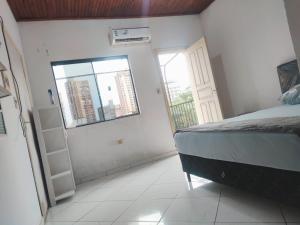 un dormitorio con una cama y una ventana en Alojamiento San Blas, en Ciudad del Este