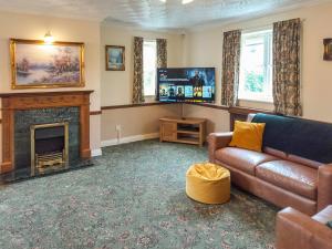 a living room with a couch and a fireplace at Brompton Lodge in Ganton