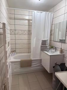 a white bathroom with a tub and a sink at Appartement Villiers sur Morin proche de Disneyland in Villiers-sur-Morin +48 photos
