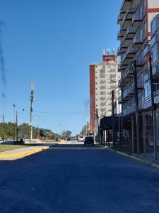 een lege straat met een auto die door de straat rijdt bij Ikigai Departamento in Santa Teresita