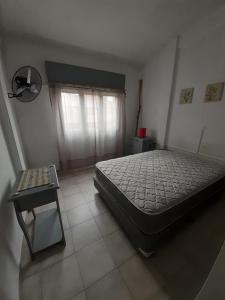 een slaapkamer met een bed en een tafel erin bij Ikigai Departamento in Santa Teresita