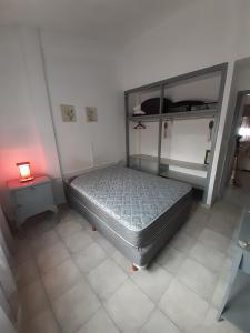 een slaapkamer met een bed en een lamp op een tegelvloer bij Ikigai Departamento in Santa Teresita +7 foto's