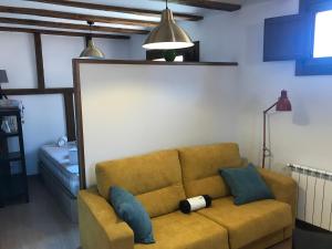 a living room with a brown couch with blue pillows at estudio judería in Sigüenza