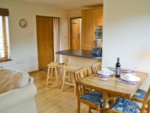 a living room with a table and a kitchen at Church View - 24731 in Bearsted