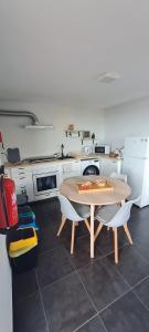 a kitchen with a table and two chairs in it at Refúgio das Regadinhas in Santa Cruz