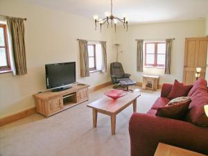 a living room with a couch and a tv at Orchard House in Parkham