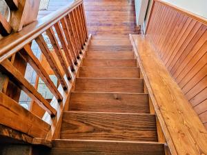 a wooden staircase in a house with wooden floors at Elm Barn Lodge in Freethorpe