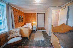 a bedroom with a bed and a chair in a room at Helgaker Gård in Gran